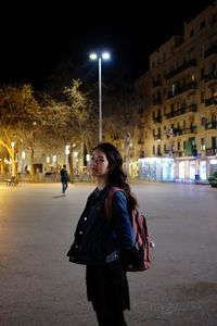 Portrait of woman standing on street at night