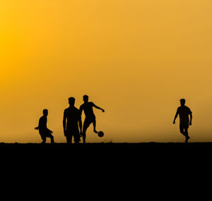 Silhouette people against clear sky during sunset