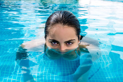 High angle portrait of teenage girl swimming in pool