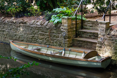 Boat moored on lake against trees