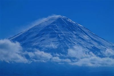 Scenic view of snowcapped mountains against blue sky