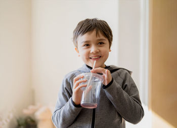 Portrait of boy drinking water from glass