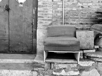 Abandoned chair against wall