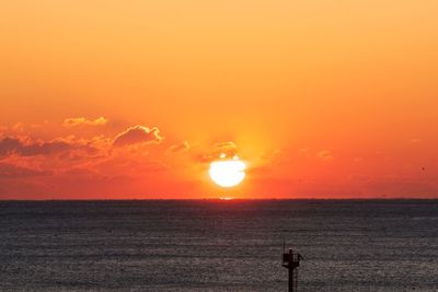 Scenic view of sea against orange sky