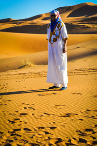 Full length of man in traditional clothes standing at desert