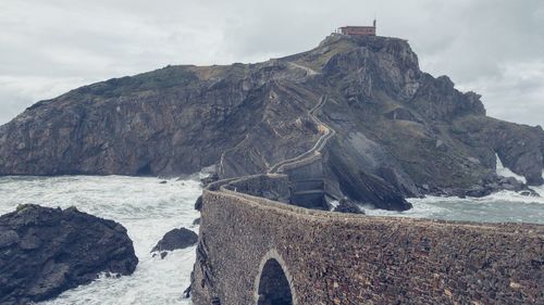 Rock formations by sea against sky