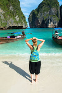 Rear view of woman standing on beach at koh phi island