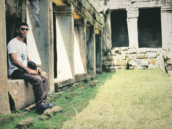 Portrait of young man sitting outside building