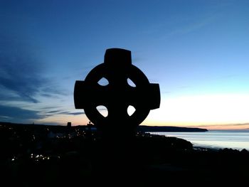 Close-up of silhouette cross against sky during sunset