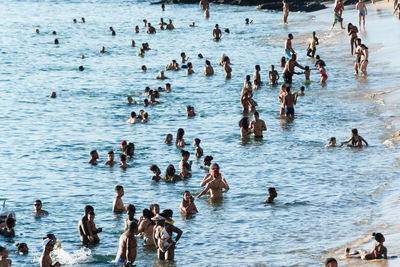 High angle view of group of people swimming in sea