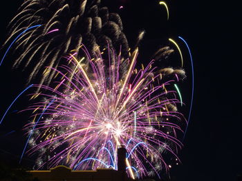 Low angle view of firework display at night