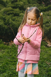 Young woman standing against plants