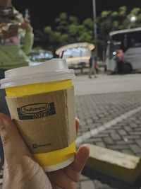 Close-up of person holding ice cream cone on street