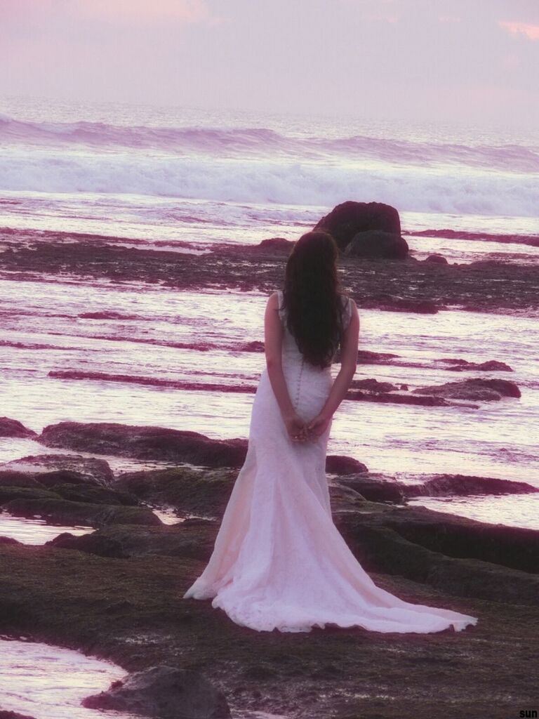 water, beach, relaxation, sunlight, nature, day, sea, outdoors, beauty in nature, sky, sand, close-up, tranquility, focus on foreground, one person, side view, shore, sitting, one animal