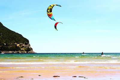 Man flying over sea against clear sky