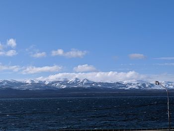 Scenic view of sea and snowcapped mountains against sky