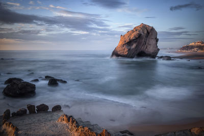 Rock formations in sea against sky