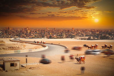 High angle view of horse cart in city against sky during sunset