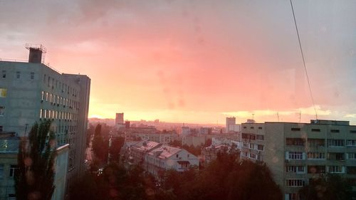 Buildings in city against sky during sunset