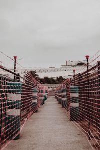 Footbridge over footpath against sky