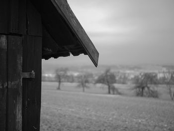 Close-up of broken wooden post on field against sky