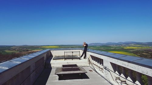 Man looking at view against clear blue sky
