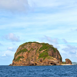 Rock formations by sea against sky