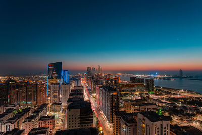 High angle view of illuminated buildings against sky at night