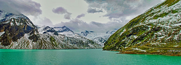 Scenic view of sea by mountains against sky