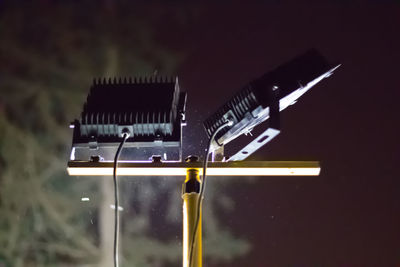 Close-up of illuminated lighting equipment against gray background