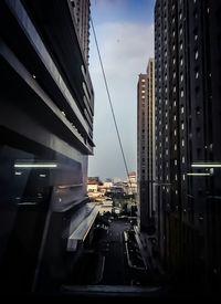 Cars on road by buildings against sky at dusk