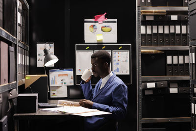 Rear view of man using laptop at office