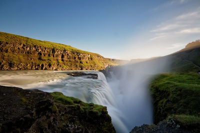 Scenic view of waterfall against sky