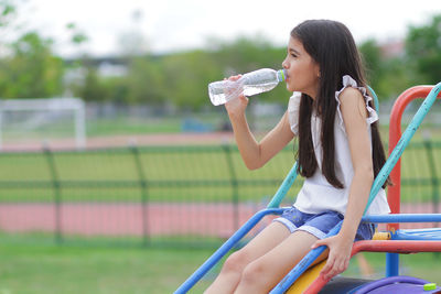 Girl drinking water at playground