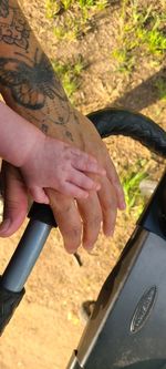 Midsection of couple holding hands in car