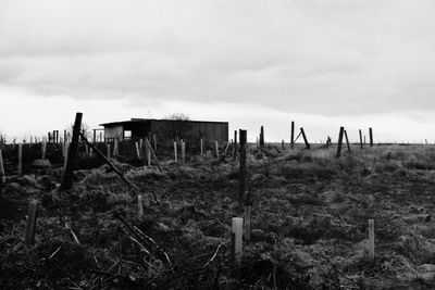 Wooden fence on field against sky