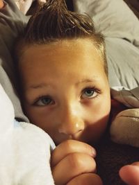 Close-up portrait of cute baby girl lying on bed at home