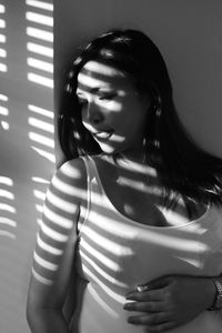 Woman standing by wall at home