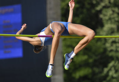 Female athlete high jumping during event