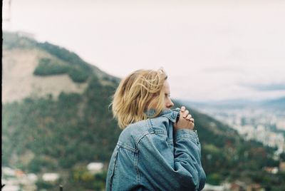 Woman standing on shore against sky