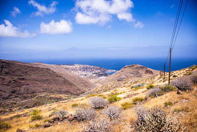 Scenic view of sea and mountains against sky