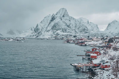 Scenic view of sea and snowcapped mountains against sky