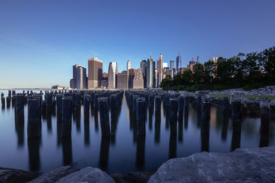 View of buildings in city against clear blue sky