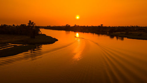 Scenic view of river against sky during sunset