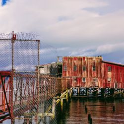 Bridge over canal in city against sky