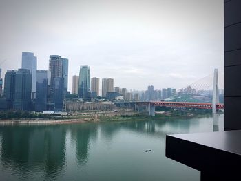 Reflection of cityscape in water against sky