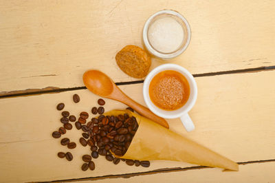 Espresso coffee and beans on a paper cone cornucopia over white background
