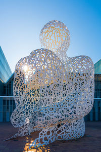 Statue against illuminated building against clear blue sky