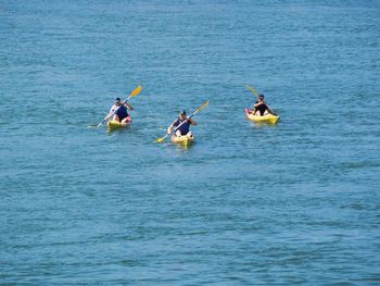 High angle view of people canoeing on sea