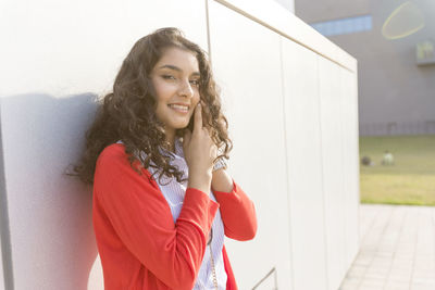 Portrait of smiling woman standing by window